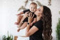 Charming happy little baby boy having fun with mom brunette woman on bed in the bright bedroom Royalty Free Stock Photo