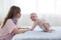 Mother and little daughter in play in the bedroom on the bed Royalty Free Stock Photo