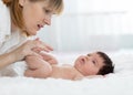 Mother and child on white bed. Parent and little kid relaxing at home. Mom doing massage baby. Royalty Free Stock Photo