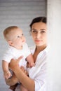 Mother and child in a white room. Mom and baby boy in diaper pla Royalty Free Stock Photo