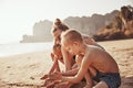 Mother and children building sandcastles together at the beach Royalty Free Stock Photo