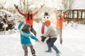 Mother And Children Building Snowman In Garden