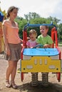 Mother and children on car toy Royalty Free Stock Photo