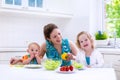 Mother and children cooking in a white kitchen Royalty Free Stock Photo