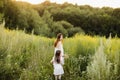 Mother with daughter walking along a country road, background summer meadow sunset, back view Royalty Free Stock Photo