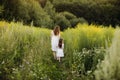 Mother with daughter walking along a country road, background summer meadow sunset, back view Royalty Free Stock Photo