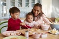 Mother And Children Decorating Cookies At Home Together Royalty Free Stock Photo