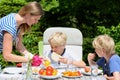 Mother with children eating outdoors