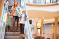 Mother And Children On Escalator In Shopping Mall Royalty Free Stock Photo