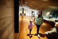 Mother with children exploring expositions in museum halls