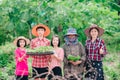 Mother and children family holding seeding plants to planting tree on blurred green nature background Royalty Free Stock Photo