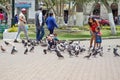 Mother and children feeding pigeons