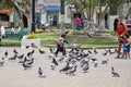 Mother and children feeding pigeons