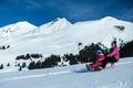 Mother and children having fun on sledge with panoramatic view of Alps mountains. Active mom and toddler kid with safety helmet. Royalty Free Stock Photo