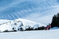 Mother and children having fun on sledge with panoramatic view of Alps mountains. Active mom and toddler kid with safety helmet. Royalty Free Stock Photo