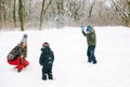 Mother and children having fun in winter park. Happy family playing with snow at winter walk outdoors Royalty Free Stock Photo