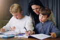 Mother, children and helping with school homework in house or learning education, teaching or lesson. Woman, sons and Royalty Free Stock Photo