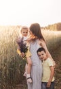 Mother with children with her son and daughter walking through a field of wheat Royalty Free Stock Photo