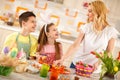 Mother and children preparing Easter basket with eggs Royalty Free Stock Photo