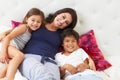 Mother And Children Relaxing In Bed Wearing Pajamas Royalty Free Stock Photo