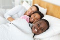 Mother and children relaxing together in bed in bedroom at home Royalty Free Stock Photo