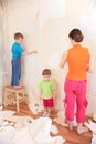 Mother with children remove old wallpapers from wa
