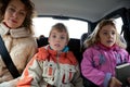 Mother with children sit on back seat of car