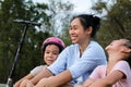 Mother and children sit and rest after riding scooters in the park. Mother and daughters spend their free time riding scooters Royalty Free Stock Photo