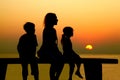 Mother with children sits on bench at beach Royalty Free Stock Photo