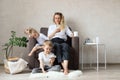 Mother and children are sitting in the living room on a chair with phones in their hands Royalty Free Stock Photo