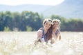 Mother with children in a summer field of blooming daisies Royalty Free Stock Photo