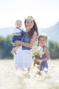 Mother with children in a summer field of blooming daisies Royalty Free Stock Photo