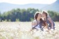 Mother with children in a summer field of blooming daisies Royalty Free Stock Photo