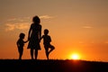 Mother and children on sunset silhouette