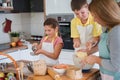 Mother and children together making apple pie in the kitchen at home. Children helping mother Royalty Free Stock Photo