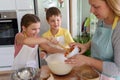 Mother and children together making apple pie in the kitchen at home. Children helping mother Royalty Free Stock Photo