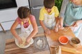 Mother and children together making apple pie in the kitchen at home. Children helping mother Royalty Free Stock Photo