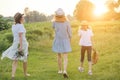 Mother with children two daughters walking along a country road, back view Royalty Free Stock Photo