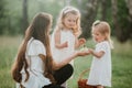 Mother and children two little daughters having fun in a meadow. Summer, nature, family, vacation. mother`s, baby`s day Royalty Free Stock Photo