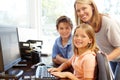 Mother and children using computer at home