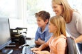 Mother and children using computer at home