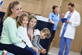 Mother and children waiting in front of registration desk in hospital