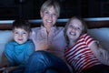 Mother And Children Watching Programme On TV Tog Royalty Free Stock Photo