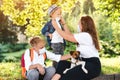 Mother and children wearing face protective medical mask. Coronavirus and real life. Kids with puppy outdoors. Home animal and pet Royalty Free Stock Photo