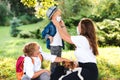 Mother and children wearing face protective medical mask. Kids with puppy outdoors. Home animal and pet Royalty Free Stock Photo