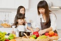 Mother and childs happy to preparing healthy food at home kitchen from vegetables and fruit