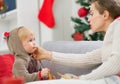 Mother cleaning eat smeared baby eating cookies