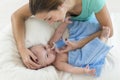 Mother cleaning nose mucus of adorable baby with a nasal aspirator