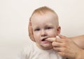 Mother cleans teeth for her little daughter, white background, close-up, portrait