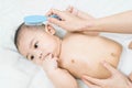 Mother is combing baby`s hair with hairbrush after bathing.selective focus